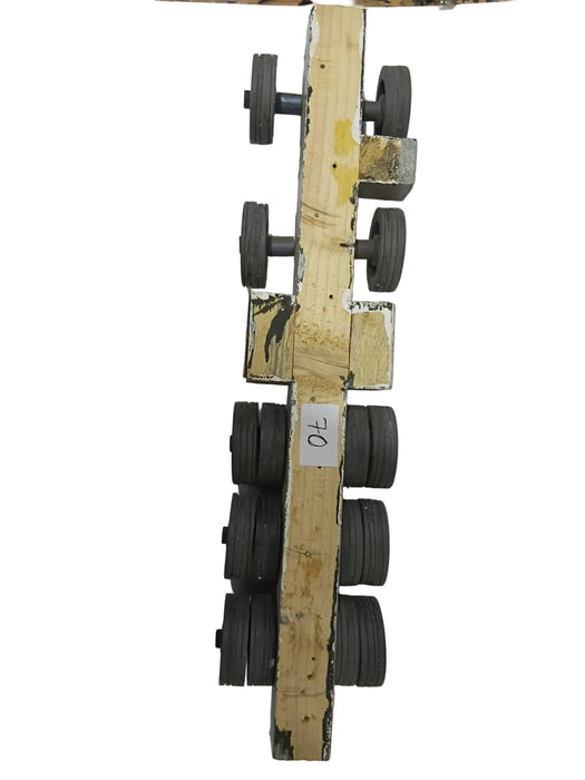 A vintage wooden roller skate frame with multiple dark gray wheels, photographed against a plain white background.